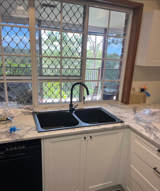 Kitchen sink installation with black tapware